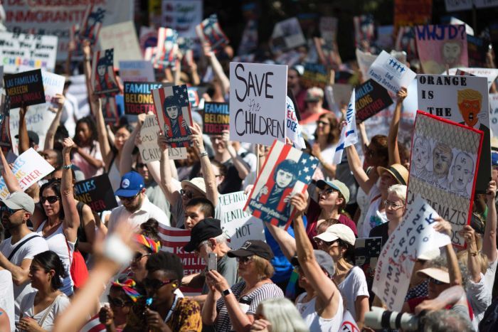 Activists hold protest signs during a rally Activists hold protest signs during a rally