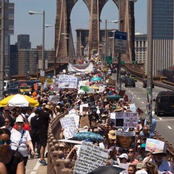 Activists carry signs across the Brooklyn Bridge Activists carry signs across the Brooklyn Bridge